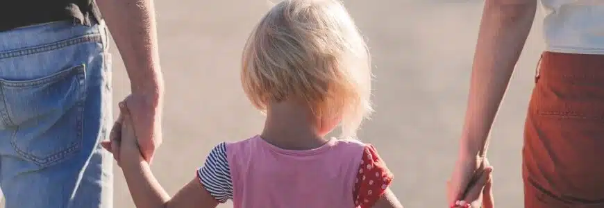 Eltern halten ein Kleinkind bei den Händen