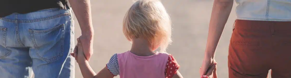 Eltern halten ein Kleinkind bei den Händen